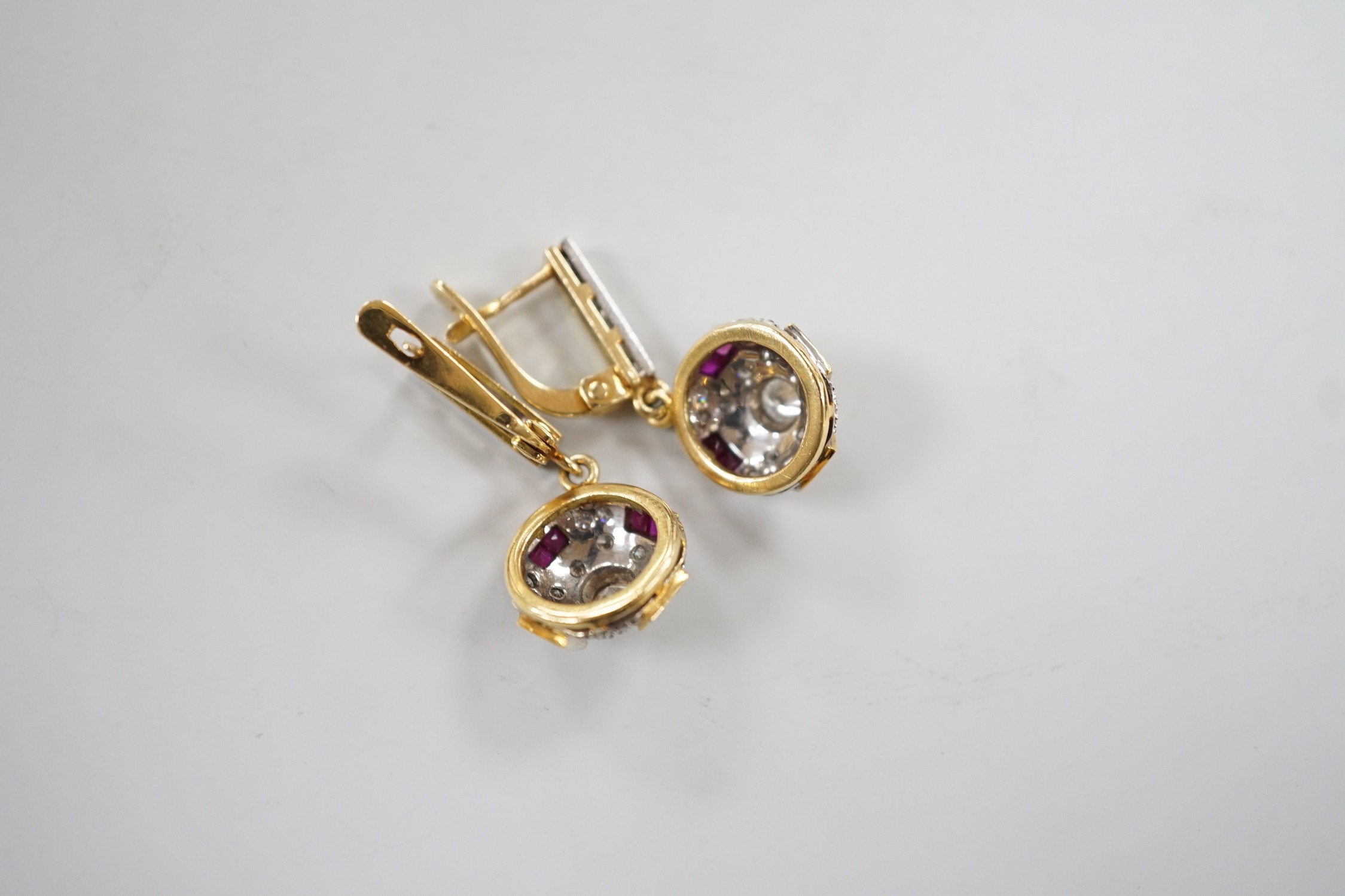 A modern pair of yellow metal, square cut ruby and round cut diamond set circular cluster drop earrings, 30mm, gross weight 8.4 grams.